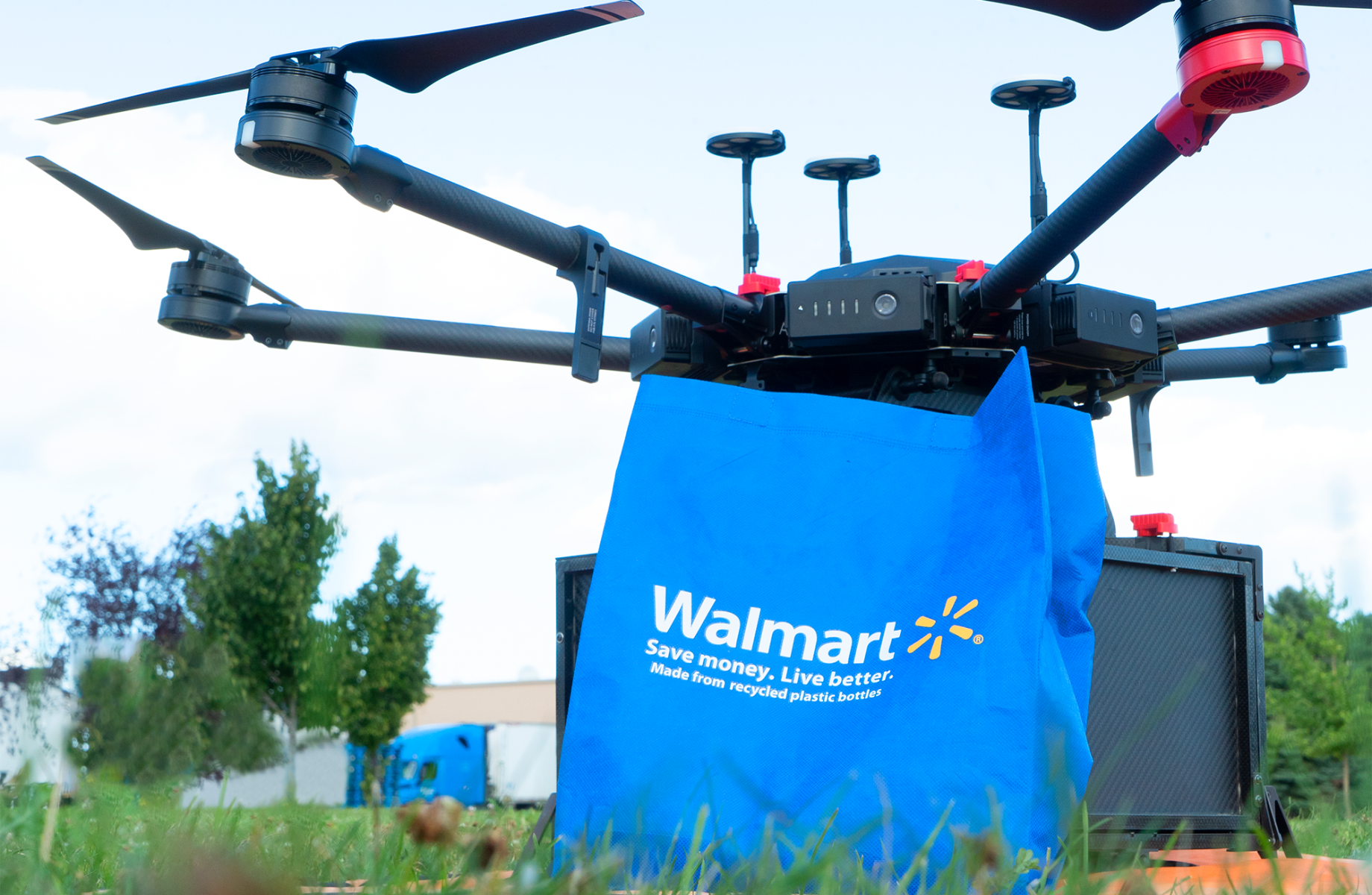 A Walmart delivery drone holding a Walmart bag