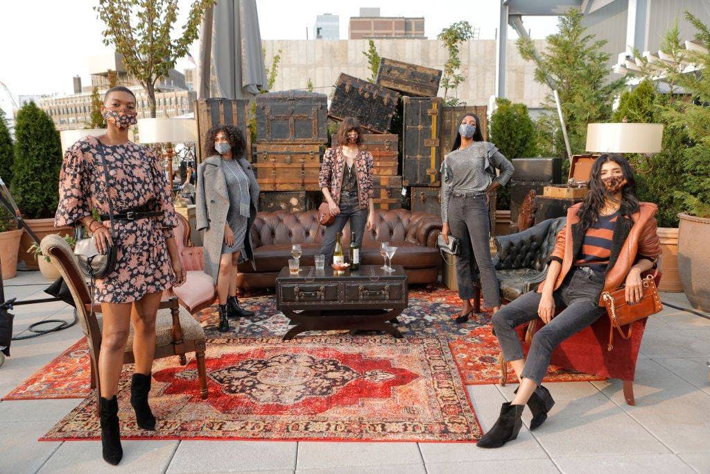 5 models lounging on chairs or standing around vintage furniture and rugs