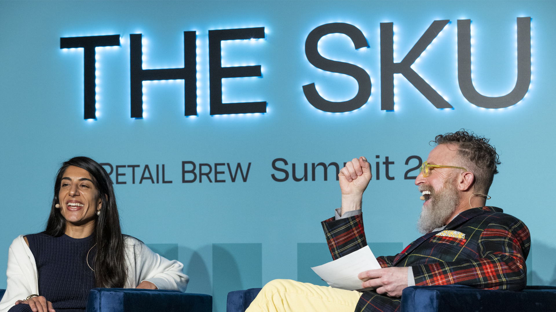 Two people sitting and talking on stage at The Sku 2022 Retail Brew event