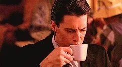 Agent Dale Cooper (Kyle MacLachlan) drinking coffee in Twin Peaks.